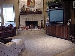 Den with corner stone fireplace, hi ceilings & built in entertainment center!
