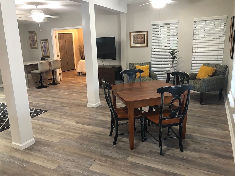Eating area borders large family room. This unit is fully furnished. One of the wall mounted TV's can be seen in the background.