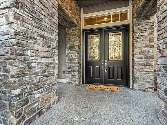 Stone adorned covered front double door entry.