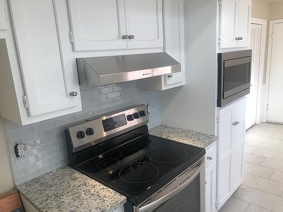 New appliances, cabinets refinished with new hardware, new tile that flows from kitchen, breakfast area, hall, utility room and into front entry, pantry has bifold doors