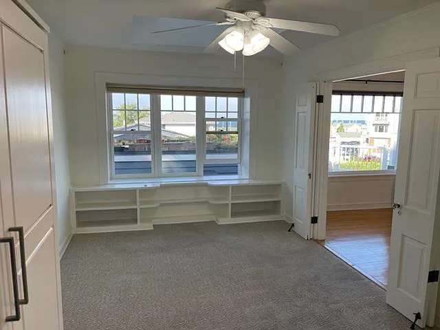 Master Bedroom with lake views, flexible floorplan and entry options including French doors, built-in shelving, wardrobe, and skylight.