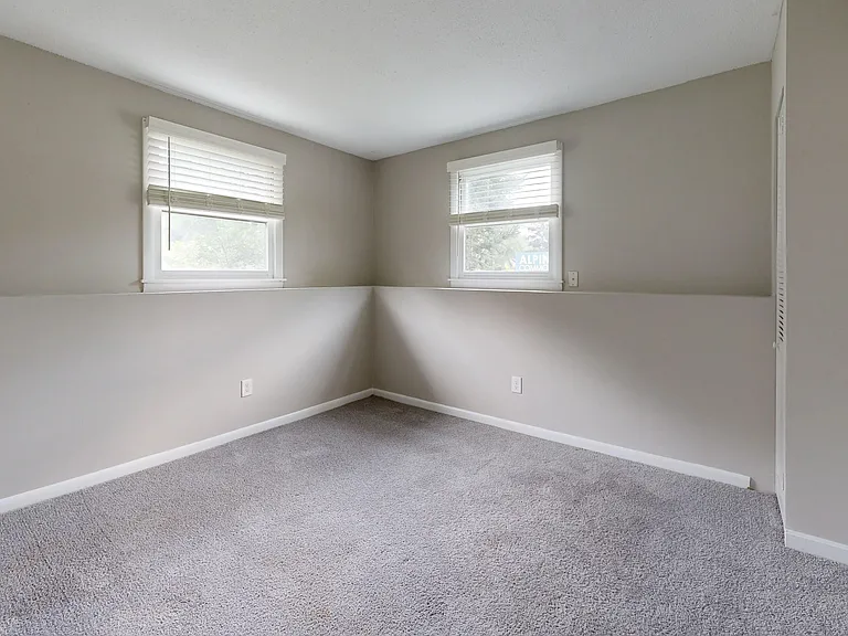 Discover the bright and airy bedroom in The Valley floor plan featuring large windows for natural light.