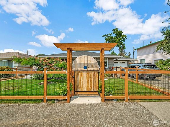 Charming custom cedar arbor and gated entry welcome you into the beautifully fenced front yard.