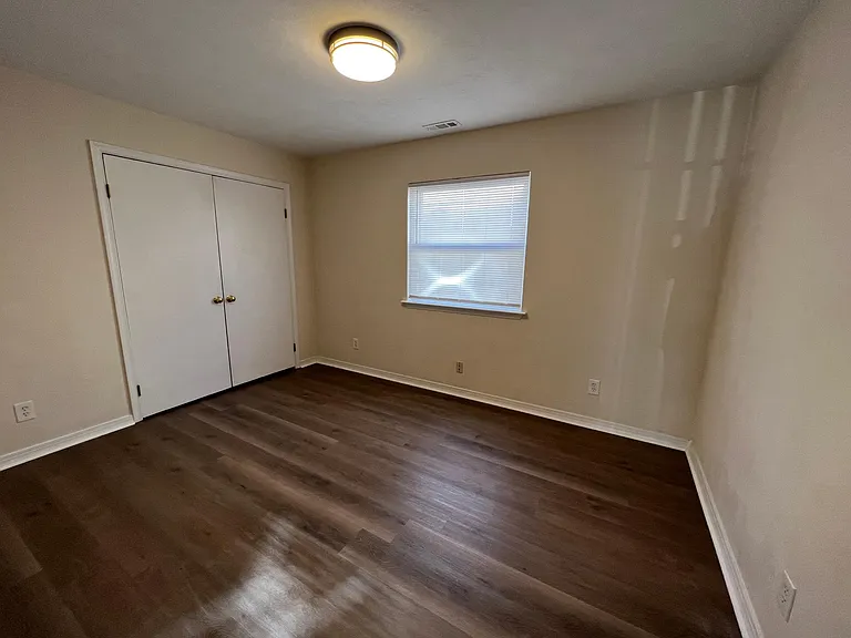 Bedroom with double closet and LED overhead lighting.