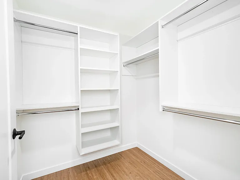 Spacious closet with built-in shelving and hanging space, offering a streamlined solution for organized storage and everyday ease.