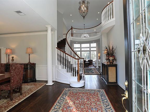 SOARING TWO STORY ENTRY WITH SPIRAL STAIRS - As you enter the home, take a moment to admire the winding staircase, wood flooring to perfection, the stunning drop down iron pendant chandelier and the spectacular eye view directly to the back yard. For