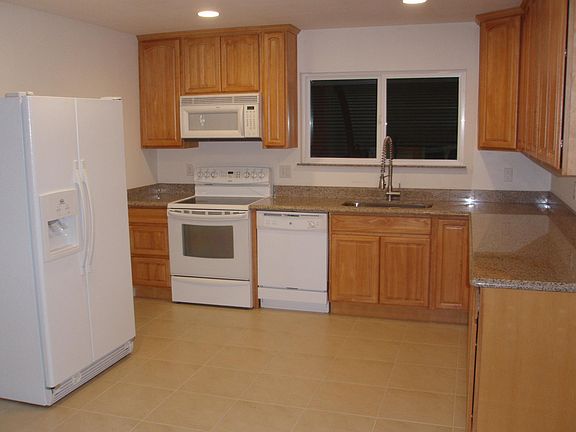 Kitchen with oak cabinets, granite countertops, and tile flo