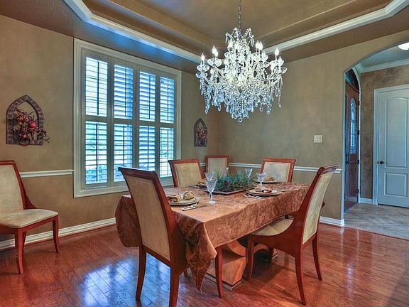 Formal dining room has wood floors, and is lighted by a Swarovski crystal chandelier.