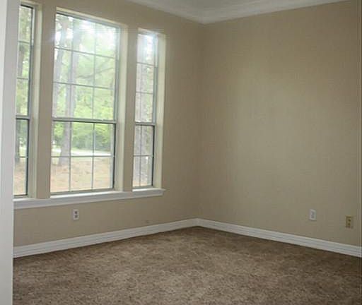 Dining Room with wall of windows, crown moulding, fresh paint and new frieze carpet!