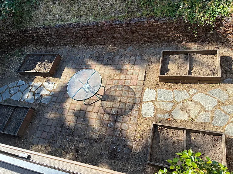 backyard area with 4 planter boxes, a seating area, and stonework