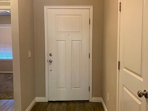 Front door. To the right is the garage door. To the left is hallway to 2 bedrooms and bathroom.