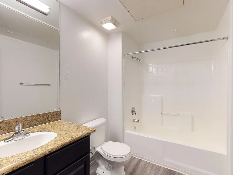 Apartment bathroom with tile flooring.