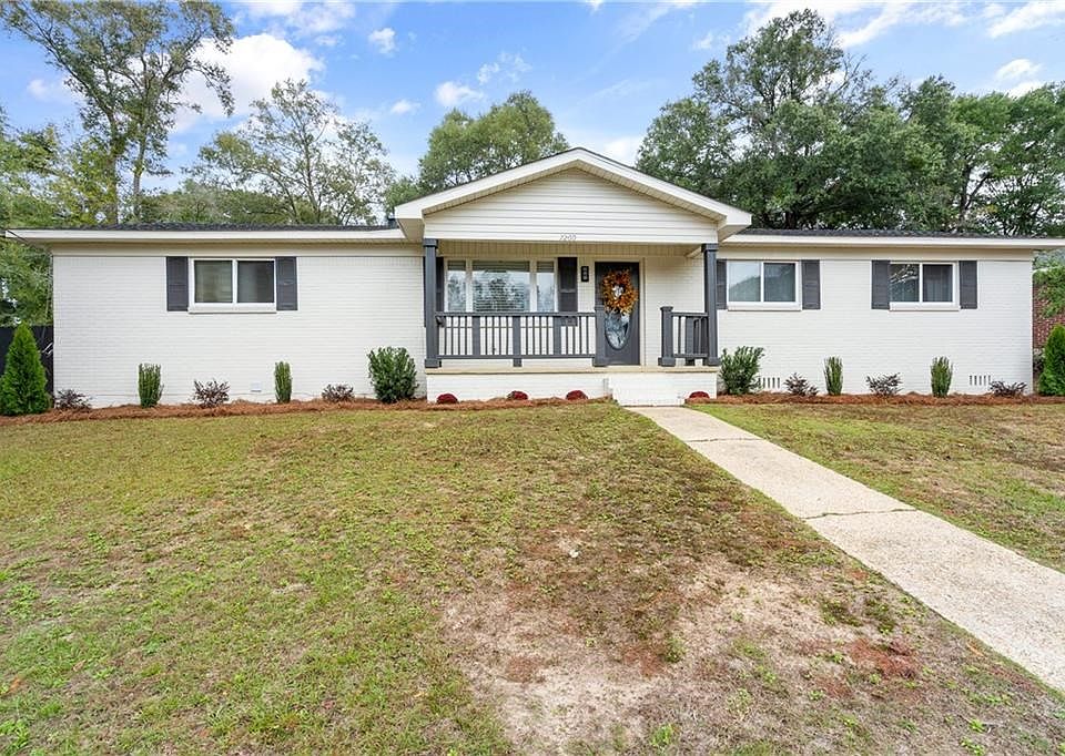Ranch-style home with a front lawn and covered porch