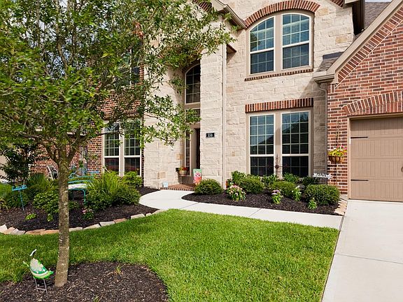 Stunning Perry Homes design, faced in stone and brick, pristine landscaping, a tandem 3-car garage, 
