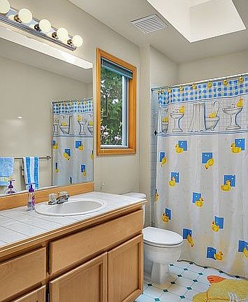 The bright and cheerful upstairs hall bath has a shower and tub. 