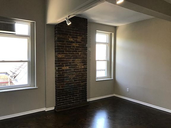 bright bedroom with exposed brick and two closets
