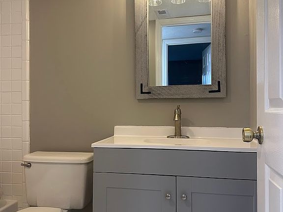Full Bath. New toilet, vanity, mirror and light fixtures.