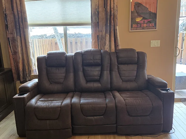 Middle seat folds down to a table. The end seats can fold back, and have a foot rest