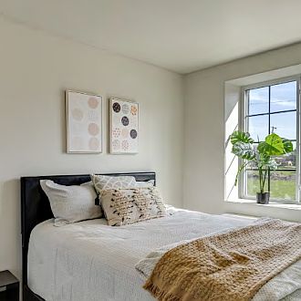 Bright and cozy bedroom featuring large windows, central AC, and sleek flooring.