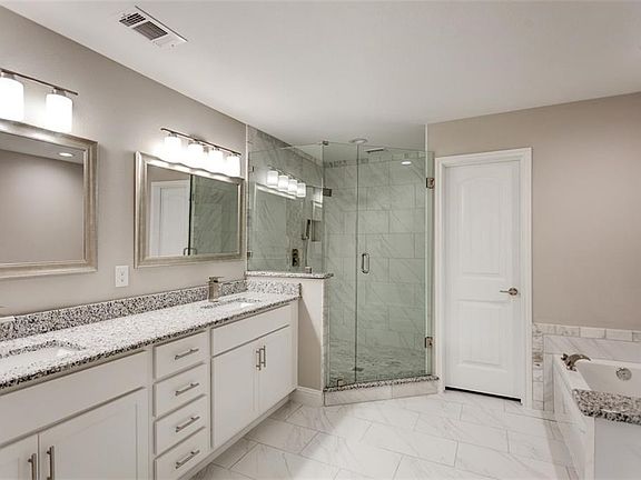 Spectacular master bath with granite counters, marbled tile floors, frame-less glass shower, soaker tub.  His and her sinks, plenty of storage space, framed mirrors, brushed nickle fixtures and hardware. Private toilet.