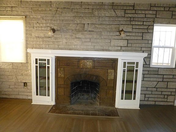 Bookshelves and mantel over the fireplace in the living room.