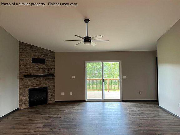 Main living room... Stone gas fireplace. Ceiling fan. Entry to covered deck.