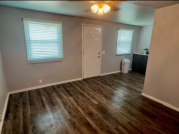 View from living room looking towards the from door and into kitchen.