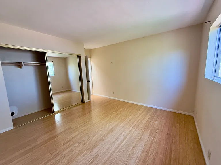 Master bedroom with doublewide mirrored closet doors.