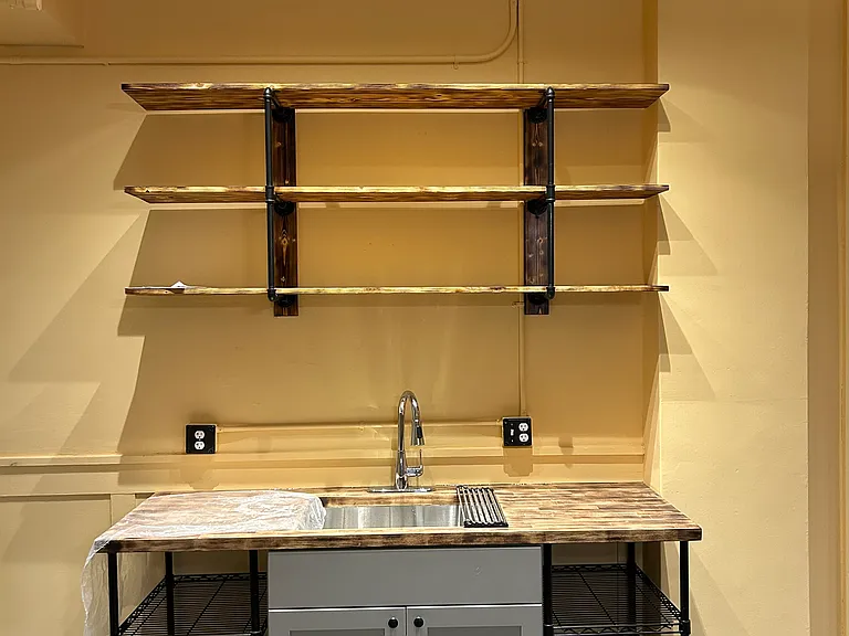 Lighting above the sink, cupboard below the sink, several outlets, and ample counter and storage space.