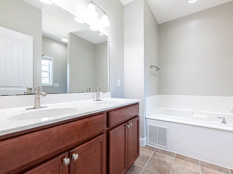Master bathroom features double vanity sink, jetted soaking tub and walk in shower