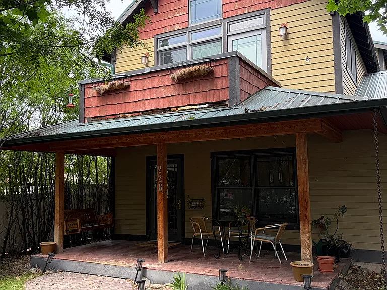 Front of house, porch and primary bedroom balcony.