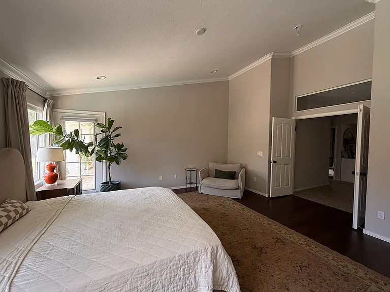 Primary bedroom featuring vaulted ceilings and a relaxing atmosphere.