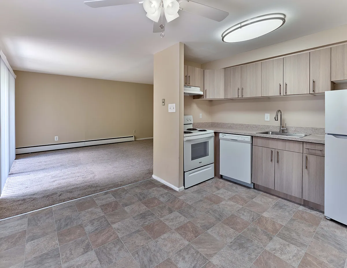 Updated kitchen with wood-style cabinets and open-concept design at Maple Terrace Apartments in Maple Shade, NJ - Maple Terrace