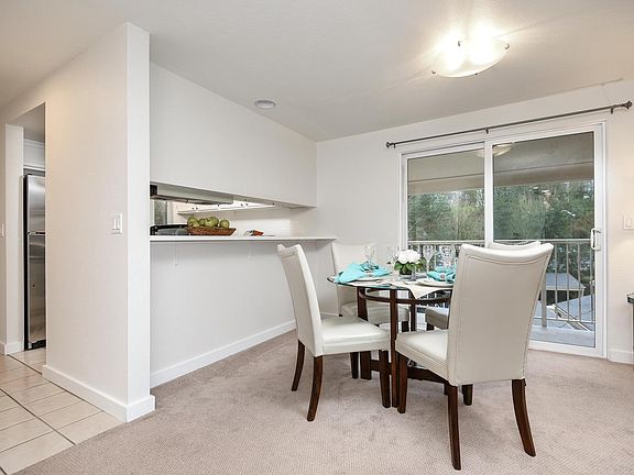 Dining area next to kitchen with large slider to balcony.