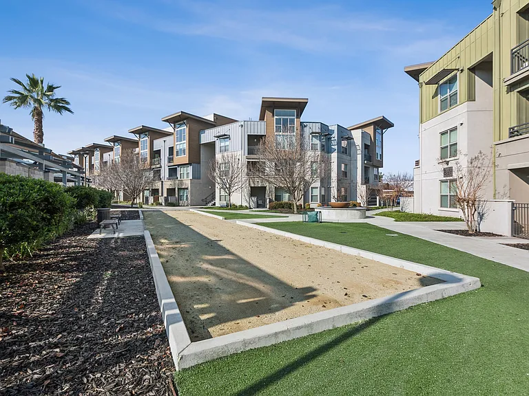 Aspire Apartments Tracy California Luxury Living Apartment complex with a fountain in the middle of a grassy area.