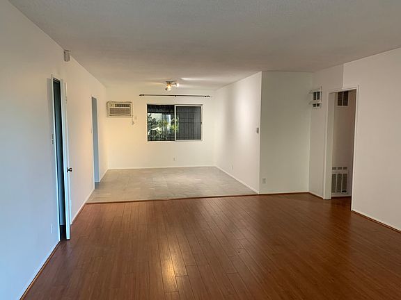 As you walk into Apt. 2, you'll enter an open plan living/dining room with an attached patio. The cracked door on the left is a spacious closet. The next entryway on the left is the kitchen. The doorway on the right takes you into the bedrooms.