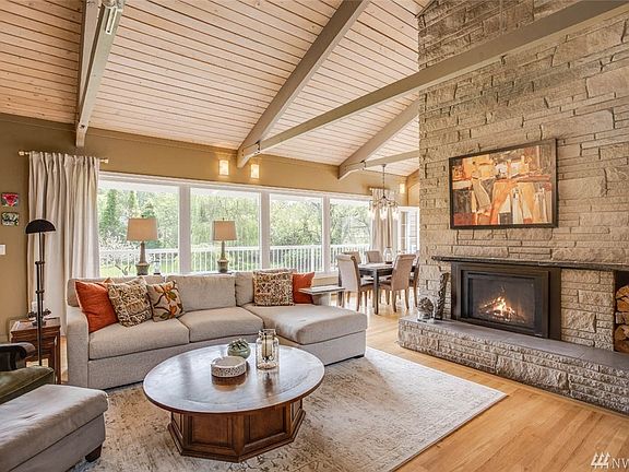 Center focus: floor to ceiling fireplace with Heat and Glow Gas Fireplace with fan and remote control. Easterly serene views of lush greenbelt landscape.