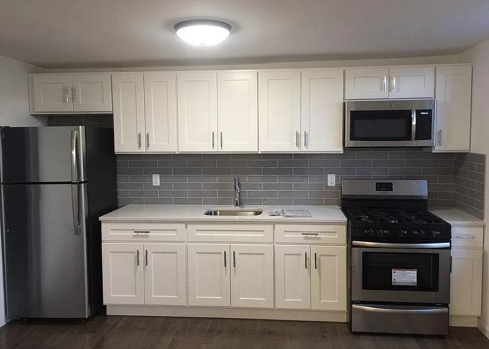 Stone Countertop with Stainless steel appliances. Tiled backsplash.