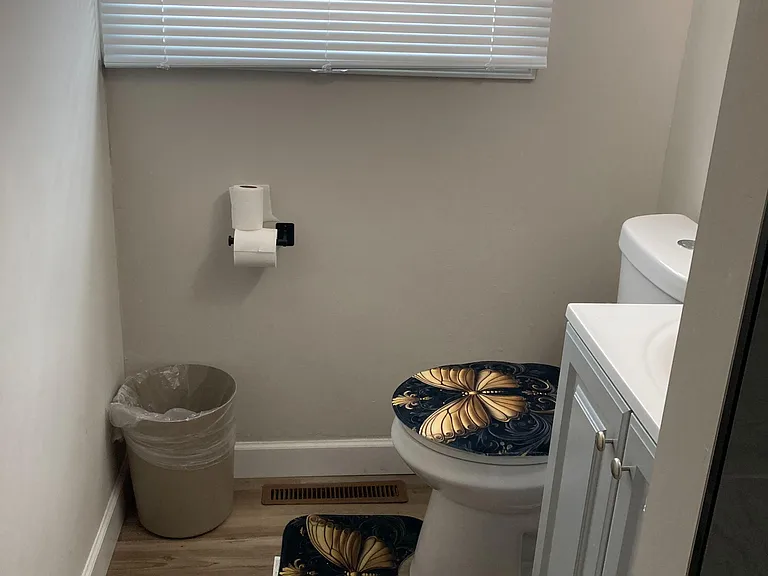 Half bath with a window for ventilation, updated vanity storage, and durable flooring for easy upkeep.