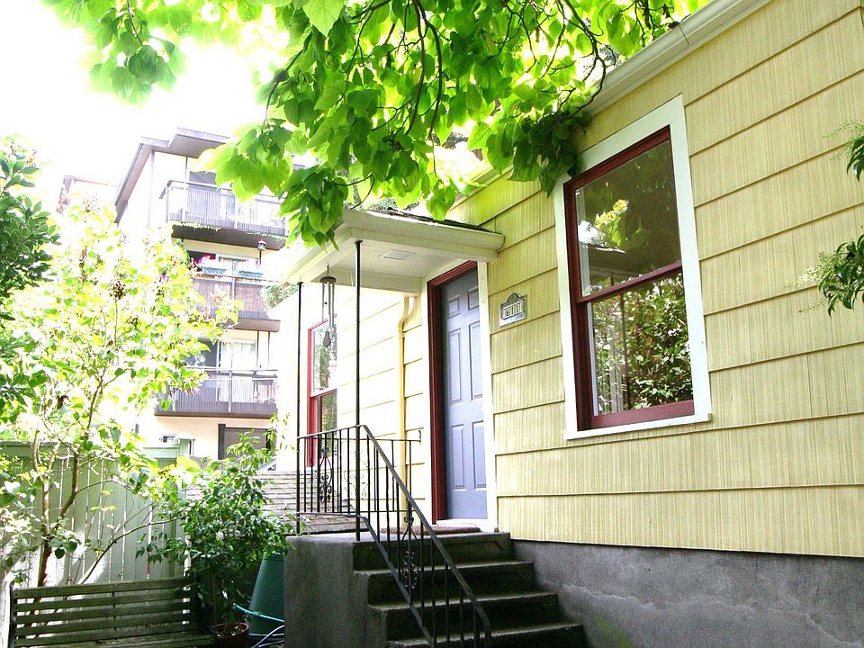 Front entrance - with a cozy yard - birdbath, wooden bench, pottery mosaic