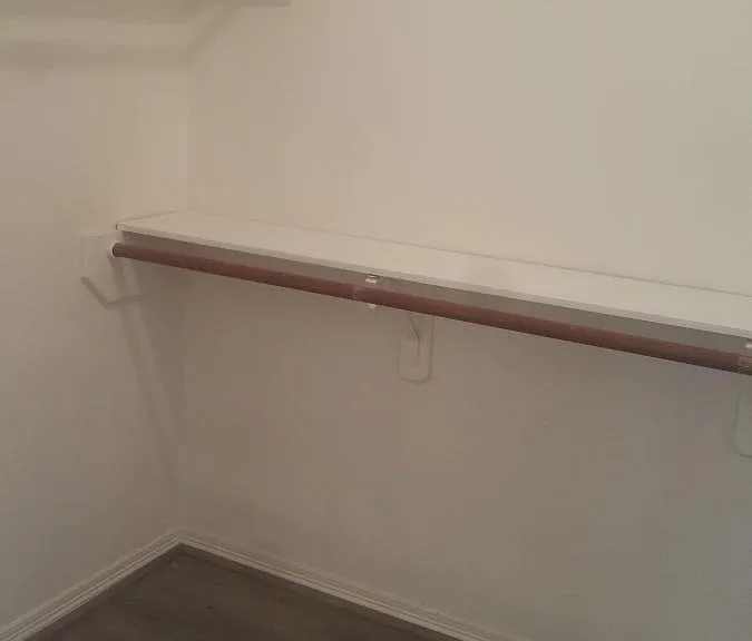 Huge walk-in closet with wood floor