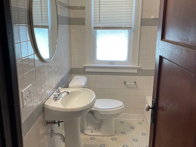 Original vintage tile on bathroom floor with update shower tile.