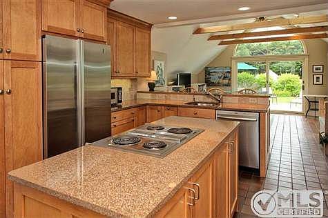 The updated kitchen opens to the family room and the decks beyond.