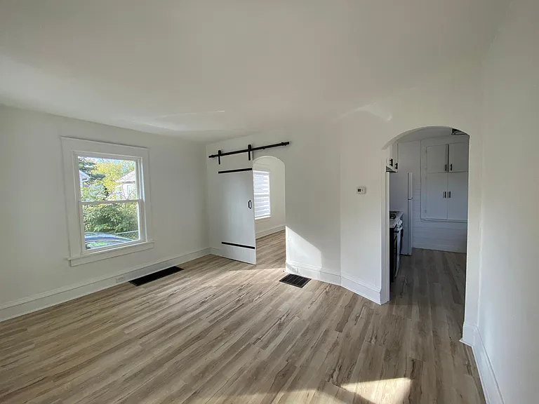 View from living room into bedroom (left) and kitchen on the right.