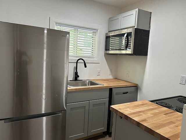 Brand new stainless kitchen with refrigerator, stove, microwave, and dishwasher