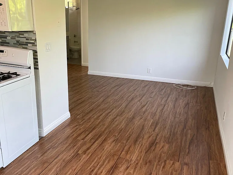 Dining area looking into living room with bedroom and bath behind living room