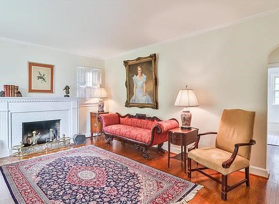 Well appointed living room with wood burning fireplace with dentil work molding