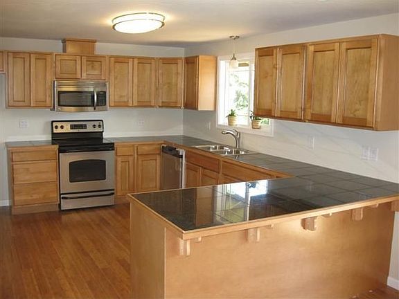 Kitchen with stainless steel appliance, granite tile counters, new cabinets