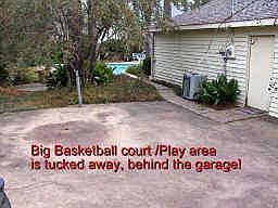 Here's another NEAT exterior FEATURE: A Basketball court/Play area, tucked away, behind the garage. 