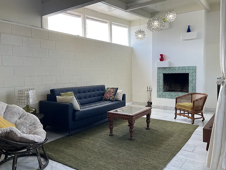 Sun filled Living Room with Leather sofa queen sleeper sofa for the occasional guest. Functioning Fireplace. Stone floor.